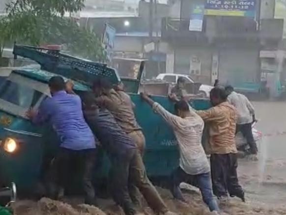 a-rickshaw-stuck-in-water-in-wadlachowk-of-sihore-the-police-came-as-an-angel-in-the-pouring-rain